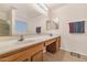 Bathroom with double sinks and a large mirror, complemented by oak cabinets at 648 W Cobblestone Dr, Casa Grande, AZ 85122