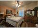 Comfortable bedroom featuring a ceiling fan, shutters and a large dresser with mirror at 650 N Hawes Rd # 4123, Mesa, AZ 85207