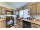 Well-equipped kitchen featuring wooden cabinets, black appliances, and a sleek countertop at 6826 S 16Th Way, Phoenix, AZ 85042