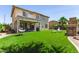 Spacious backyard with artificial grass, a covered patio, outdoor furniture, and mature landscaping at 6870 S Crestview Dr, Gilbert, AZ 85298