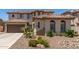 Beige two-story home with a brown roof, lush landscaping, and a two-car garage at 6870 S Crestview Dr, Gilbert, AZ 85298