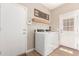 Bright laundry room featuring a modern washer and dryer, wood-style flooring, and access door at 6870 S Crestview Dr, Gilbert, AZ 85298