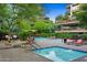 Outdoor swimming pool, lounge chairs, and grill for community enjoyment with lush surrounding trees at 7137 E Rancho Vista Dr # 6011, Scottsdale, AZ 85251