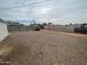 Large gravel-covered backyard with fencing, utility poles, and neighboring houses in background at 7139 E Arcadia Cir, Mesa, AZ 85208