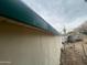 Close-up of home's exterior, highlighting weathered siding and green trim on a cloudy day at 7139 E Arcadia Cir, Mesa, AZ 85208