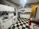 Retro kitchen featuring black and white checkered floors and white cabinetry with red trim at 7139 E Arcadia Cir, Mesa, AZ 85208