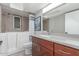 Well-lit bathroom with a walk-in tub, a neutral-toned countertop, and wooden cabinets at 7727 E 4Th St, Scottsdale, AZ 85251