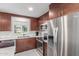 Well-lit kitchen with stainless steel appliances, wood cabinets, and a subway tile backsplash at 7727 E 4Th St, Scottsdale, AZ 85251