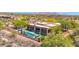 Aerial view of a desert estate featuring a long pool, an artificial lawn, and a backdrop of scenic mountains at 8300 E Lone Mountain Rd, Scottsdale, AZ 85266