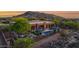 Desert home featuring a large pool, landscaping, and mountain views at sunset at 8300 E Lone Mountain Rd, Scottsdale, AZ 85266