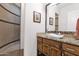 This bathroom vanity features a vessel sink, granite countertop and wood cabinets with a tiled shower in the background at 8300 E Lone Mountain Rd, Scottsdale, AZ 85266
