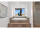 A bathtub in the bathroom overlooks mountain desert views through a large window at 8300 E Lone Mountain Rd, Scottsdale, AZ 85266