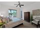 Cozy bedroom with neutral tones and views of desert vegetation, complemented by a ceiling fan and ample natural light at 8300 E Lone Mountain Rd, Scottsdale, AZ 85266