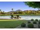 Expansive backyard featuring a pond, golf course view, and lounge chairs on a deck at 8312 N Golf Dr, Paradise Valley, AZ 85253