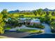 House exterior with golf course and mountain views, mature trees, and a circular driveway at 8312 N Golf Dr, Paradise Valley, AZ 85253