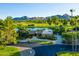 Beautiful house with golf course and mountain views, mature trees, and manicured landscaping on a sunny day at 8312 N Golf Dr, Paradise Valley, AZ 85253