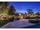 A grand front exterior with a circular driveway, arched entryway, and lush landscaping at 8312 N Golf Dr, Paradise Valley, AZ 85253
