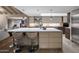 Bright, open kitchen with a large island and bar stools overlooking the living area at 8312 N Golf Dr, Paradise Valley, AZ 85253