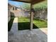 Private fenced backyard with manicured synthetic lawn and stone patio with a covered sitting area at 8981 W Tuckey Ln, Glendale, AZ 85305