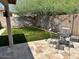 Enclosed backyard showing patio area with decorative garden furniture and an easy-to-maintain synthetic grass area at 8981 W Tuckey Ln, Glendale, AZ 85305