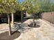 Cozy backyard featuring desert landscaping, trees, and a stone-paved patio area perfect for relaxing or entertaining guests at 8981 W Tuckey Ln, Glendale, AZ 85305