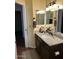 Bathroom features a granite countertop, dark wood cabinet, and updated fixtures at 8981 W Tuckey Ln, Glendale, AZ 85305