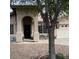 Welcoming home front entrance with an arched entryway, complemented by a quaint seating area and established landscaping at 8981 W Tuckey Ln, Glendale, AZ 85305