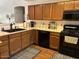 Open kitchen area with wooden cabinets, black appliances, and an expansive countertop, creating an inviting workspace at 8981 W Tuckey Ln, Glendale, AZ 85305
