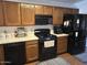 Well-lit kitchen with a combination of wooden cabinetry and black appliances, great for everyday cooking at 8981 W Tuckey Ln, Glendale, AZ 85305