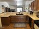 Spacious kitchen that opens to the living area, complete with wooden cabinets and a cozy dining area at 8981 W Tuckey Ln, Glendale, AZ 85305