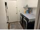 Functional laundry room featuring a washer, dryer, and shelving for storage and a doorway to the side at 8981 W Tuckey Ln, Glendale, AZ 85305