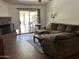 Cozy living room with fireplace, wood-look floors, sectional sofa, and sliding glass door to the backyard at 8981 W Tuckey Ln, Glendale, AZ 85305