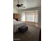 Relaxing main bedroom highlighting a window nook, comfortable carpet, and a ceiling fan at 8981 W Tuckey Ln, Glendale, AZ 85305