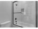 Modern bathroom with tub and shower featuring sleek glass doors, tile surround, and dark hardware at Xxx S Hunt Hwy, Queen Creek, AZ 85142