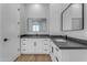 Bright bathroom boasts double vanities with sleek black hardware, granite counters, and wood-look floors at Xxx S Hunt Hwy, Queen Creek, AZ 85142