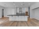 Spacious kitchen with large island, white cabinets, dark countertops, and hardwood floors at Xxx S Hunt Hwy, Queen Creek, AZ 85142