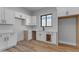 Modern kitchen features white cabinets, stainless sink, and wood-look flooring at Xxx S Hunt Hwy, Queen Creek, AZ 85142