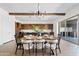 Open concept dining room with modern light fixture, wood beams, and dining table set for dinner at 10134 E Talon Ave, Mesa, AZ 85212