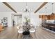 Open concept dining room with modern light fixture, wood beams, and dining table set for dinner at 10134 E Talon Ave, Mesa, AZ 85212