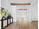 Bright entryway with wooden beams, light hardwood floors, and white walls create a welcoming and modern aesthetic at 10134 E Talon Ave, Mesa, AZ 85212