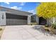 Exterior elevation of a modern home with three-car garage, desert landscaping, and gray stucco at 10134 E Talon Ave, Mesa, AZ 85212