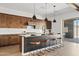 Kitchen island with barstool seating, pendant lighting, stainless appliances, and modern cabinets with white countertops at 10134 E Talon Ave, Mesa, AZ 85212