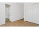 Bright, empty room with wood-look floors and an ensuite bathroom with tiled shower at 10134 E Talon Ave, Mesa, AZ 85212