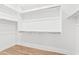 Bright, empty walk-in closet featuring shelving and wood-look flooring at 10134 E Talon Ave, Mesa, AZ 85212
