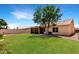 Well-maintained backyard featuring a large lawn, mature tree, block fence, and screened-in porch at 10320 W Luke Ave, Glendale, AZ 85307