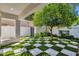 Stylish backyard features a checkered turf design, a shady tree, and a gated entrance at 10360 N 98Th St, Scottsdale, AZ 85258