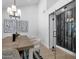 Modern dining room with a long table, elegant chandelier, and glass-enclosed storage at 10360 N 98Th St, Scottsdale, AZ 85258