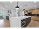 Modern kitchen featuring a large island with a microwave, sleek wooden cabinets, and open shelving at 10360 N 98Th St, Scottsdale, AZ 85258