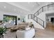 Spacious living room with a modern staircase, neutral tones, and a view of the outdoor pool at 10360 N 98Th St, Scottsdale, AZ 85258