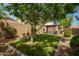 Backyard featuring an artificial lawn, mature trees, gazebo with a trampoline, and privacy fence at 10452 E Natal Ave, Mesa, AZ 85209